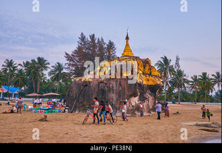 CHAUNG THA, MYANMAR - 28. FEBRUAR 2018: Die großen Felsen an der Küste von Bengal Bucht mit goldenen Stupa Kyauk Pa Hto-Pagode gekrönt wird, im Februar Stockfoto