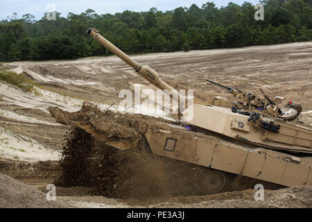 Marines mit Alpha Company, 2. Tank Battalion, Antrieb einen M1 Abrams Tank über eine Schmutz berm während ein Fahrzeug gegen die Übung an Bord Techniker Ausbildung im Bereich 2, Camp Lejeune, N.C., Sept. 17, 2015. Marines mit mobilen Angriff Unternehmen, 2 Combat Engineer Battalion, nutzten ihre Fahrzeuge einen Pfad durch die BERM zu verstoßen, für die Tanks zu folgen. (U.S. Marine Corps Foto von Cpl. Paul S. Martinez/Freigegeben) Stockfoto