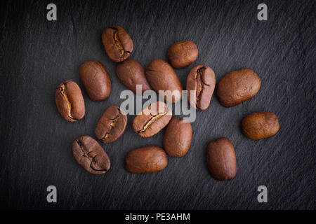 Kaffeebohnen auf schwarzem Schiefer Hintergrund. Close Up. Stockfoto