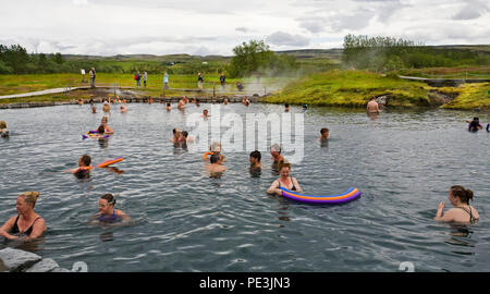 Touristen aus Europa und den Vereinigten Staaten Baden in einer von Islands zahlreiche heiße Quellen. Das ist die Geheime Lagune, in der Nähe von Flodir, Stockfoto