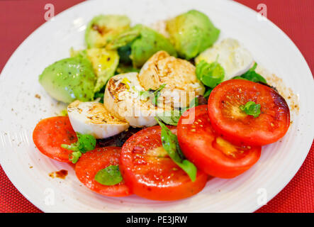 Gesunde Lebensweise: typisch mediterranen Diät, tricolore Salat Zutaten in Scheiben geschnittenen roten Tomaten, White Buffalo Mozzarella und grünen Avocado pear Stockfoto