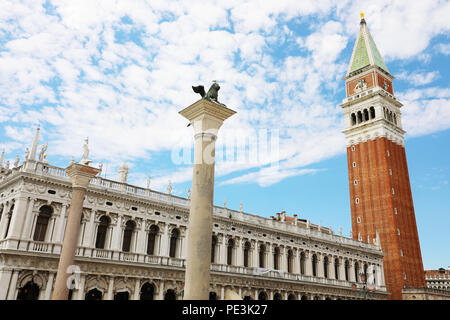 Weiße Wolken im blauen Himmel auf St. Markusplatz mit Glockenturm und Lion Statue in Venedig, Italien Stockfoto