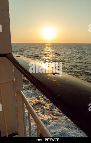 Holzgeländer des Schiffes vor dem Meer und Sonnenuntergang Stockfoto