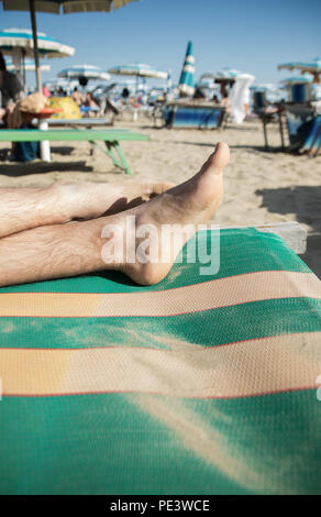 Festlegung der Füße auf Sand layered Strandkorb Stockfoto