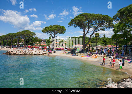 "Menschen am Strand von Lazise, Gardasee, Verona, Italien | Menschen am Strand von Lazise, Gardasee, Provinz Verona, Italien Stockfoto