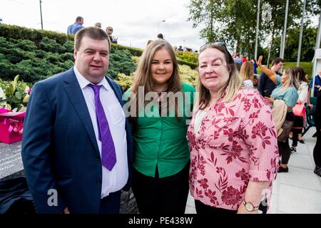 Omagh Bombe überlebenden Gary McGillion (links) und Frau und anderen Überlebenden Donna Marie McGillion (rechts), mit ihrer Tochter Cara McGillion 16 (Mitte), die mit den Omagh Gemeinschaft Chor auf eine inter-konfessionelle Service im Memorial Gardens in Omagh Omagh Bombenanschlag zu erinnern, die 20 Jahre auf. Stockfoto