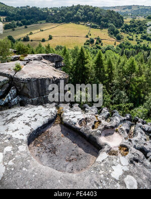 Cratcliffe Tor in der Nähe von The Staff Of Life in Derbyshire UK zeigen gritstone Kante, die durch Wind, Wasser und Kies in Rock Becken verwittert und Kannelierten runnels Stockfoto