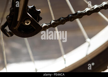 Closeup makro Bild eines schmierigen Fahrrad Kette mit dem Schalthebel im Rahmen sichtbar. Defokussierten Bereich für Fokus auf der Kettenglieder. Stockfoto