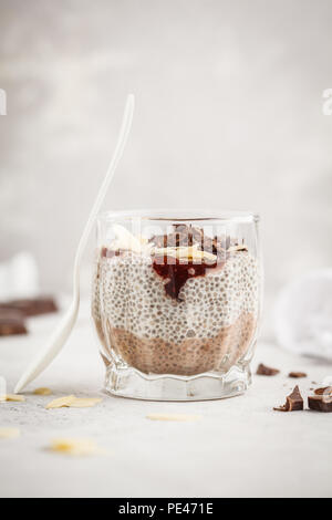 Chia Pudding mit Schokolade, Mandeln und Berry Konfitüre, weißen Hintergrund. Raw vegan Dessert. Saubere Konzept essen. Stockfoto