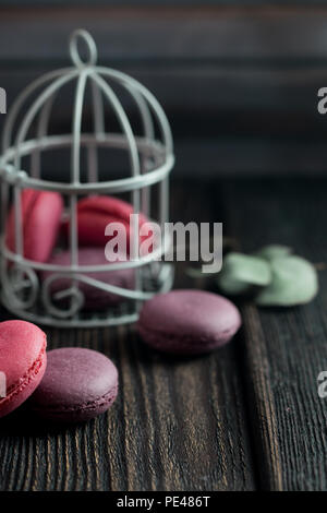 Gruppe der Macarons aus Erdbeeren, Sahne, Schokolade und Heidelbeeren. Rustikale Foto. Getönt. Stockfoto