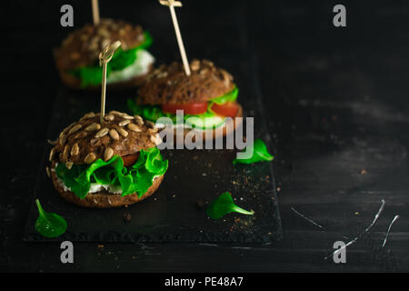 Grüne Sandwich mit Salat, Tomaten, Gurken und Frischkäse auf Beton. Stockfoto