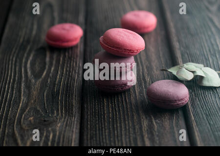 Gruppe der Macarons aus Erdbeeren, Sahne, Schokolade und Heidelbeeren. Rustikale Foto. Getönt. Stockfoto