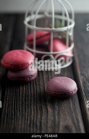 Gruppe der Macarons aus Erdbeeren, Sahne, Schokolade und Heidelbeeren. Rustikale Foto. Getönt. Stockfoto