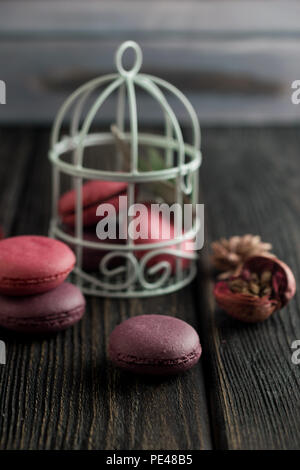 Gruppe der Macarons aus Erdbeeren, Sahne, Schokolade und Heidelbeeren. Rustikale Foto. Getönt. Stockfoto