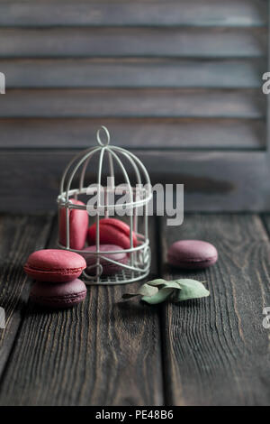 Gruppe der Macarons aus Erdbeeren, Sahne, Schokolade und Heidelbeeren. Rustikale Foto. Getönt. Stockfoto