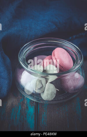 Gruppe der Macarons aus Erdbeeren, Sahne, Schokolade und Heidelbeeren. Rustikale Foto. Getönt. Stockfoto