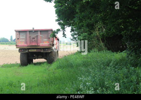 Farm trailer links im Feld im Frühling Stockfoto