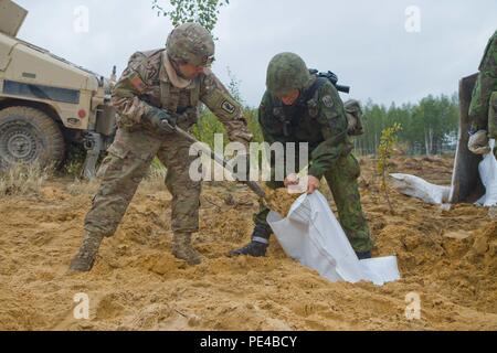 Us-Armee Fallschirmjäger, Pvt. Philip Rebelo, ein Eingeborener von Rocky Point, New York, zu Hund Unternehmen, 1.BATAILLON, 503Rd Infanterie Regiment, 173Rd Airborne Brigade, und die Litauische Landstreitkräfte Ingenieur, Pvt zugeordnet. Evaldas Dabuzin, ein Eingeborener von Kaunas zu den allgemeinen Ingenieur Coy, Juozas Vitkus Engineer Battalion, arbeiten zusammen, Sandsäcke, die während der Übung Ingenieur Thunder 2015 an der Großen Litauischen Hetman Jonusas Radvila Training Regiment, in Rukla, Litauen, Sept. 9, 2015 gehalten zu füllen zugeordnet. Die Schulung gab den 173Rd Airborne Brigade die Möglichkeit mit Ingenieuren auszubilden und zu lernen, wie man am besten utiliz Stockfoto