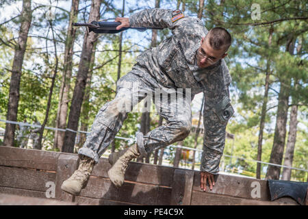 Armee finden Drill Sergeant des Jahres Kandidat, Staff Sgt. Mark Mercer, 95 Abteilung Weiterbildung (IET), springt über die hohe Mauer auf das Fit zu Parcours gewinnen, während der dritte Tag des 4-tägigen TRADOC Drill Sergeant des Jahres Wettbewerb in Fort Jackson, S.C., Sept. 7-10, 2015. Mercer ist in einem Kopf-an-Kopf Wettbewerb mit Staff Sgt. Russell Vidler, 98th Abteilung Weiterbildung (IET), um den Titel der besten Armee finden Drill Sergeant. (U.S. Armee Foto von Sgt. 1. Klasse Brian Hamilton) Stockfoto