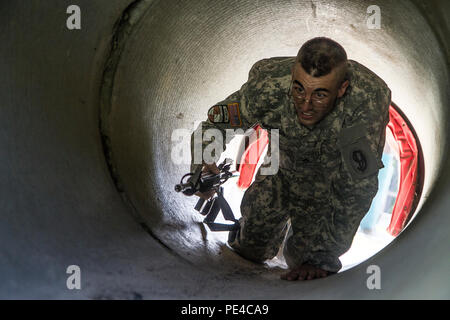 Armee finden Drill Sergeant des Jahres Kandidat, Staff Sgt. Mark Mercer, 95 Abteilung Weiterbildung (IET), kriecht durch eine Drainage Düker auf die Passung an das Hindernis Kurs gewinnen, während der dritte Tag des 4-tägigen TRADOC Drill Sergeant des Jahres Wettbewerb in Fort Jackson, S.C., Sept. 7-10, 2015 statt. Mercer ist in einem Kopf-an-Kopf Wettbewerb mit Staff Sgt. Russell Vidler, 98th Abteilung Weiterbildung (IET), um den Titel der besten Armee finden Drill Sergeant. (U.S. Armee Foto von Sgt. 1. Klasse Brian Hamilton) Stockfoto