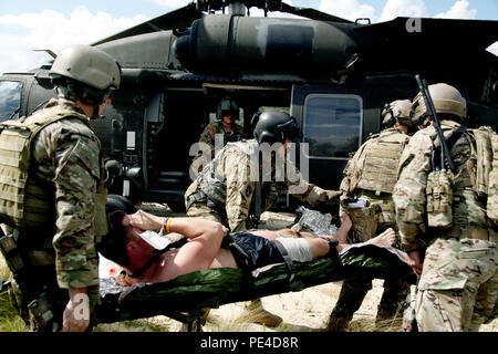 Soldaten aus 3 Special Forces Group, unterstützt von Fallschirmjägern aus Charlie Company, 3. Allgemeine Unterstützung Aviation Battalion, 82nd Combat Aviation Brigade, einem simulierten Unfall auf einem UH-60 Black Hawk Last während zusammengeschlossen, um die Ausbildung, Fort Bragg, N.C., Sept. 8. Einmal an Bord, wurde der Patient zu Simmons Army Airfield transportiert und simulierte Behandlung durch spezielle Operationen Ärzte und Mediziner. (U.S. Armee Foto: Staff Sgt. Christopher Freeman/82nd CAB PAO) Stockfoto