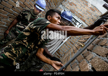 Tentera Darat Malaysia Cpl. Azlan Rosli, ab 2 Squadron Royal Engineer Regiment, und der US-Armee SPC. Chris Lake, ein Louisiana nationalen Scots Guards Plummer von 1020Th Ingenieur Unternehmen, inlay Rohrleitungen in der Backstein während der Schule bauen neben der Operation Keris Streik, Pacific Pathways 2015 Tai Ping, Malaysia, an Sept. 9, 2015. Betrieb Keris Streik ist eine regelmäßig geplante bilaterale Übung gesponsert von US-Army-Pacific, gehostet, die jährlich durch die Tentera Darat Malaysia regionale Sicherheit, Unterstützung und Zusammenarbeit zu fördern. (U.S. Armee Foto von SPC. Michael Sharp / freigegeben) Stockfoto