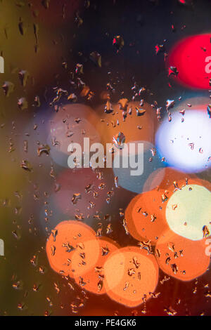 Regentropfen auf Fenster mit bunten bokeh Hintergrund Stockfoto