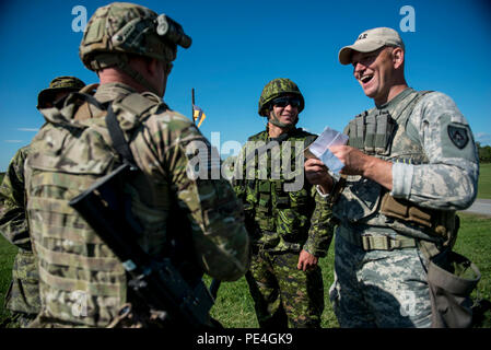 Chief Warrant Officer zwei Andy Knote (links), von North Chicago, und Staff Sgt. Jason Godel, von San Antonio, US-Armee finden internationale Combat Team Wettbewerber, Witz mit kanadischen Soldaten, bevor Sie auf einer 7 Kilometer langen Gewehr militärischer Biathlon übereinstimmen, die mehrere physische Hindernisse während der 2015 kanadischen Streitkräften Kleinwaffen Konzentration am Connaught Bereich außerhalb von Ottawa, Kanada, Sept. 14. Die internationale Treffsicherheit der Wettbewerb dauerte ungefähr zwei Wochen, die in mehr als 250 insgesamt Mitbewerber aus den Britischen, Kanadischen und US-amerikanischen Streitkräfte in konkurrierenden Stockfoto