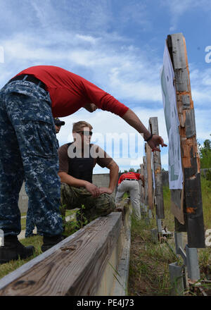 150915-N-TI 693-105 SOUTHPORT Fla (Sept. 15, 2015) - Master-at-Arms 1. Klasse Chris Halusan, an Bord der Naval Support Activity Panama City (NSA-PC) mit dem Harbour Patrol Unit und die wirkende SAMMI (kleine Arme Treffsicherheit Ausbilder), von Hartland, Wis stationiert, weist auf die feuerte Gruppierung zur Marine Diver 2. Klasse Nathan Blair, mit der Navy Experimental Diving Unit stationiert, von Greenwood Lake, New York, Segler aus verschiedenen Mieter Aktivitäten an Bord NSA PC ihre halbjährliche Marine Feuerwaffen Qualifikation an der Golfküste State College Schießplatz leiten. (U.S. Marine Foto von Massenkommunikation Sp Stockfoto