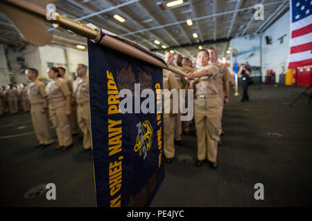 150916-N-TE 278-020 WESTLICHEN PAZIFISCHEN OZEAN (Sept. 16, 2015) - Vierzig - ein Chief Petty Officer selectees render Ehren während ihrer pinning Zeremonie an Bord der Nimitz-Klasse Flugzeugträger USS Ronald Reagan (CVN 76). Ronald Reagan und seine eingeschifft Air Wing, Carrier Air Wing (Cvw) 5, eine Bekämpfung bereit, Kraft, schützt die kollektive maritime Interessen seiner Verbündeten und Partnern in der Indo-Asia-Pazifik-Region. (U.S. Marine Foto von Mass Communication Specialist 2. Klasse Paolo Bayas/Freigegeben) Stockfoto