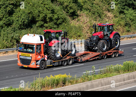 Tieflader mit zwei Traktoren auf der Autobahn. Stockfoto