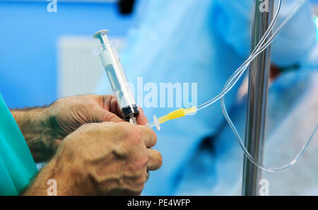 Doctor's Hand und Infusion Tropf im Krankenhaus auf unscharfen backgroun Stockfoto