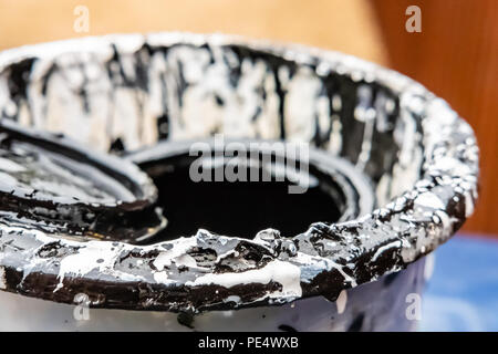 Nahaufnahme, flacher Fokus Bild einer fast leeren Dose schwarzer Glanzfarbe in der Heimdekoration verwendet. Stockfoto