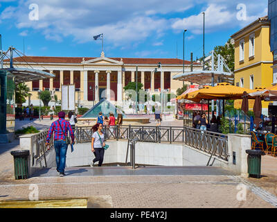 Plateia Korai Platz mit der U-Bahn U-Bahn Station Eingang in den Vordergrund und der Nationalen und Kapodistrias-Universität Athen im Hintergrund. Athen. Stockfoto