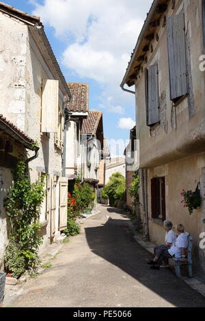 Zwei ältere Frauen in einer mittelalterlichen Straße sitzen, Issigeac Bastide, Dordogne Frankreich Europa Stockfoto