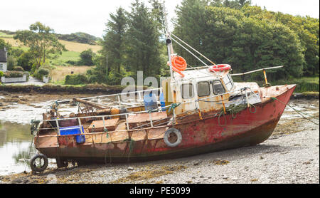 Rusty, ein Rosten Schiff zerstört Rumpf bis auf einem Creek Küste gebunden ist. Stockfoto