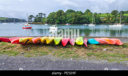Zeilen aus Kunststoff Kajaks umgedrehten auf einem Kieselstrand, West Cork, Irland Stockfoto