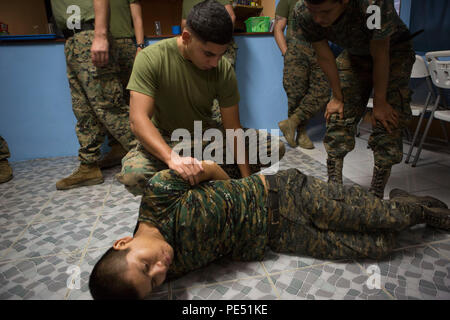 Us Marine Corps Cpl. Jose L. Alcala, Sacramento, Calif. native und ein Ausbilder mit Sicherheit Zusammenarbeit Team-Guatemala, Special Purpose Marine Air-Ground Task Force-Southern Befehl zeigt, Handschellen Techniken zu Marines und Soldaten mit der Brigada de Infanteria Marina, während eines städtischen bekämpfen Kurs in Puerto Barrios, Guatemala, Sept. 29, 2015. SPMAGTF-SC ist eine vorübergehende Entsendung von Marinesoldaten und Matrosen in Honduras, El Salvador, Guatemala und Belize mit einem Fokus auf den Aufbau und die Pflege von Partnerschaften mit jedem Land durch gemeinsame Werte, Herausforderungen und Stockfoto