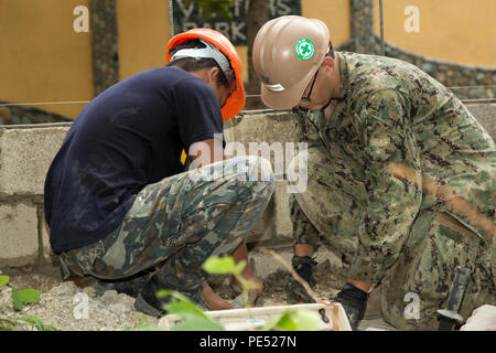 Ein philippinischer Seemann und US-Navy Seabee Petty Officer 3rd Class Anthony Carreno, Stahl Arbeitnehmer, 9. Unterstützung der Techniker Bataillon, 3d Marine Logistics Group, bauen eine Wand als Teil der humanitären civic Hilfe Projekt in Concepcion Volksschule in Palawan, Philippinen, während amphibische Landung PHIBLEX Übung 2015 (15), 6. 15 PHIBLEX ist eine jährliche bilaterale Ausbildung Übung mit der Streitkräfte der Philippinen durchgeführt, um die Interoperabilität zu stärken und die Zusammenarbeit in einem breiten Spektrum von militärischen Operationen von der Katastrophenhilfe bis hin zu komplexen expeditionar Stockfoto