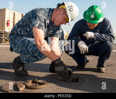 151007-N-ZZ 999-046 SAN DIEGO (Okt. 2010) 07, 2015) der Luftfahrt Bootsmann Mate (Ausrüstung) in der 2. Klasse Christopher Kraemer, Links und eine zivile Auftragnehmer Test ein Kabel support Schraubenbohrung auf dem Flugzeugträger USS Carl Vinson (CVN 70) Flight Deck. Carl Vinson unterzieht sich einem Chef der Marineoperationen geplante schrittweise Verfügbarkeit Mindestreserve-erfüllungsperiode in ihren Heimathafen San Diego. (U.S. Marine Foto von Mass Communication Specialist Seaman Tom Tonthat/Freigegeben) Stockfoto