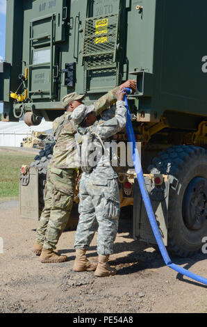 Sgt. Tony Clinton und SPC. Natalie Smith, beide Wasseraufbereitung Spezialist mit Die 129 Bekämpfung Sustainment Support Bataillons, Luftlandedivision Sustainment Brigade, Luftlandedivision (Air Assault), haken Sie einen Schlauch auf einer System-kompatiblen Wassertank Rack, auch genannt ein Hippo, es mit Wasser, das durch die taktische Wasserreinigungssystem Sept. 3, 2015 gereinigt wurde zu füllen, bei mittleren Staging Basis die gemeinsame Bereitschaft Training Center in Alexandria, Louisiana. Die Wasseraufbereitung Team mit Die 129 CSSB ist Teil einer Ausbildung Rotation an JRTC Unterstützung der Stockfoto