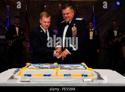 Airman Ryan Darish, 86th medizinischen Support Squadron Uniform Business Office Techniker, und Gen. Frank Gorenc, US Luft Kräfte in Europa und Afrika Commander, schneiden Sie einen Kuchen in die Luftwaffe Kugel, Sept. 12, 2015, an der Air Base Ramstein, Deutschland. Der Kuchen Cutting ist eine Luftwaffe Tradition, in der der niedrigste und höchste Flieger im Zimmer der Kuchen zusammen geschnitten. (U.S. Air Force Foto/Airman 1st Class Larissa Greatwood) Stockfoto