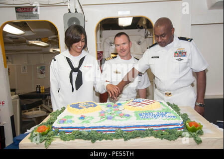 151013-N-GG 458-086 USS Arlington, auf See (Okt. 13, 2015) Seaman Gabrielle Maldonado, von Houston, Kommandierender Offizier Kapitän Sean Bailey, von Wyoming, Kan., und Chief Warrant Officer James Prioleau, von Augusta, Ga, schneiden Sie einen Kuchen in der Feier des 240. Geburtstag der Vereinigten Staaten der Marine auf das Chaos Decks des amphibious Transport dock Schiff USS Arlington LPD (24). Arlington ist unterwegs auf der Jungfernfahrt als Teil der Kearsarge Amphibious Ready Gruppe (KSGARG) Einsatz zur Unterstuetzung der Maritime Security Operations und Theater Sicherheit Zusammenarbeit in den USA 6 Flotte Bereiche der r Stockfoto