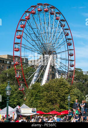 M&Ds großen Riesenrad in die Princes Street Gardens, Princes Street, Edinburgh, Schottland, UK gegen den blauen Himmel im Sommer mit Festival Ständen auf dem Damm Stockfoto