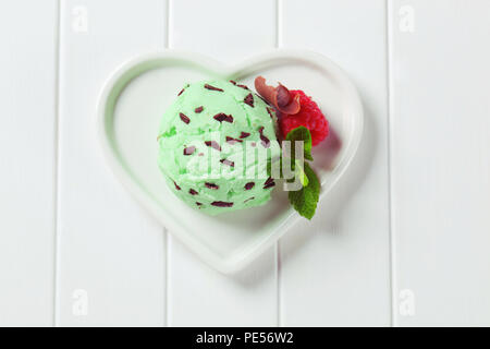 Scoop der mint Chocolate Chip Eis auf herzförmige Platte Stockfoto