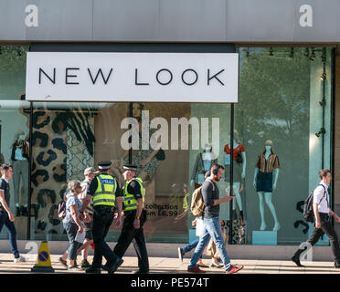 Käufer und Polizisten hinter die Fassade des neuen Store mit Puppen in Glas Fenster schauen, Princes Street, Edinburgh, Schottland, Großbritannien Stockfoto