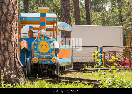 Kleine Kinder sind Reiten auf der Bahn in den Park. Stockfoto