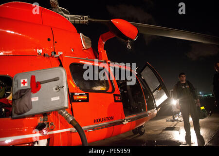 Lt. Zach Gross, einem MH-65 Hubschrauberpilot, disembarks das Flugzeug nach einer Ausbildung Flug mit Air Station Houston, Sept. 29, 2015. Nacht Operations Training bereitet die Flugzeugbesatzungen Für die gewaltige Aufgabe, eine Rettung mit sehr wenig Licht und schlechter Sicht. (U.S. Coast Guard Foto von Petty Officer 3. Klasse Dustin R. Williams). Stockfoto