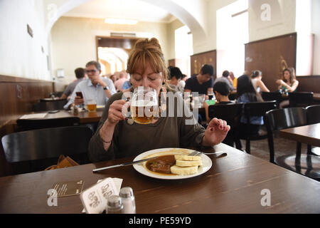 Frau mit Glas der traditionellen klassischen tschechischen Bier und Essen im Lokal Dlouhaaa Bier Pub Restaurant in Prag, Tschechische Republik Stockfoto