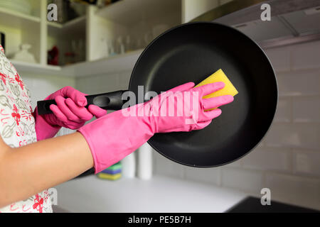 Weibliche Händewaschen Pfanne. Junge Hausfrau Frau waschen Bratpfanne in einer Küche Spüle mit einem gelben Schwamm, Handreinigung, manuell von Hand, housew Stockfoto